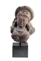 A PINK SANDSTONE FRAGMENTARY BUST OF DURGA, CENTRAL INDIA, CIRCA 10TH CENTURY