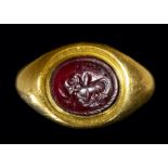 A SASANIAN GARNET INTAGLIO SET IN A GOLD RING. ZEBU.