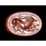 AN ETRUSCAN CARNELIAN SCARAB. LION WITH CRESCENT MOON.