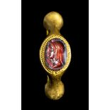 A FINE GREEK PTOLEMAIC GARNET INTAGLIO SET IN A LATER GOLD RING. BUST OF ISIS.