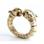 DAVID WEBB: flexible gold bracelet with pair of tiger heads, white enamel, rubies and diamonds