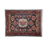 A CAUCASIAN RED GROUND WOOL RUG, the rectangular field with central octagonal shaped medallion