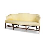 A MAHOGANY FRAMED HUMPBACK SOFA IN HEPPLEWHITE STYLE serpentine seat on eight mahogany and