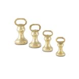 A SET OF FOUR BRASS BELL WEIGHTS in sizes, each with weight engraved to the handle,