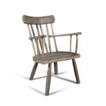 A 'GIBSON' STAINED WOOD ARMCHAIR, spindle back and flat armrests on splayed legs