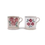 TWO BELLEEK SPONGEWARE MUGS, decorated with red and green flowers, with stepped foot base.