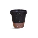 A LARGE TERRACOTTA MILK CROCK, the moulded rim above black glazed body with moulded handles.
