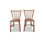 A PAIR OF 19TH CENTURY PAINTED PINE CURVED RAILBACK CHAIRS, the stick back and dished saddle seat,