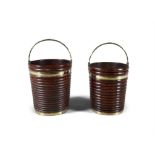 A PAIR OF RIBBED MAHOGANY BUCKETS, EARLY 19TH CENTURY with brass coopering and swing handles (2).