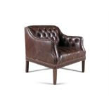 A LARGE BUTTONBACK CLUB ARMCHAIR, covered in a brown leather with brass studding,