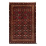A RED GROUND BOKHARA WOOL RUG, AFGHANISTAN, 214 x 141cm the central field woven with