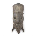 A LARGE TRIBAL CARVED WOOD MASK with pierced eyes and mouth, carved with segmented interlinked