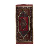 AN OLD TURKISH KONYA WOOL RUG, S.W TURKEY, C.1970, 115 x 50cm The central field woven with red