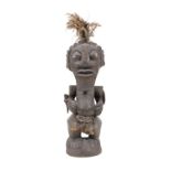 A PACIFIC ISLANDS CEREMONIAL FIGURE covered in dark pigments, inset cowrie shell eyes,