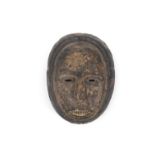 AN AFRICAN OVAL FACE MASK, POSSIBLY FANG with buff and charred pigment, with pierced eyes.