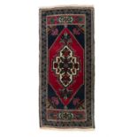 AN OLD TURKISH TAŞPINAR WOOL RUG, CENTRAL TURKEY, C. 1970, 110 x 50cm The central field woven