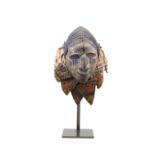 A SMALL AFRICAN YORUBA MASK carved with distinctive facial features, with kaolin traces and