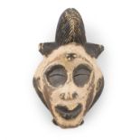 AN ASHIRA-BAPUNU DANCERS MASK, GABON with kaolin and black pigments, and raised coiffeur.