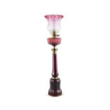 A VICTORIAN RUBY GLASS AND BRASS MOUNTED TALL MALLET SHAPED OIL LAMP with ruby glass fluted