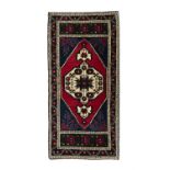 AN OLD TURKISH TAŞPINAR WOOL RUG, CENTRAL TURKEY, C.1970, 113 x 53cm The central field woven