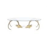 COFFEE TABLE An oval glass topped coffee table on a pair of brass rams' heads. 141 x 70 x 42cm(h)