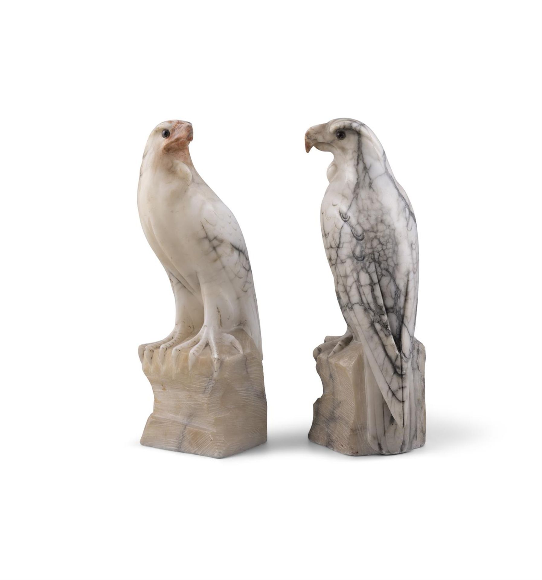 A PAIR OF CARVED WHITE VARIEGATED MARBLE MODELS OF HAWKS PERCHED ON ROCKY OUTCROPS. 31cm high