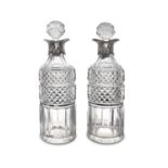 A PAIR OF VICTORIAN CUT GLASS CYLINDRICAL OIL BOTTLES with silver collars and with diamond cut
