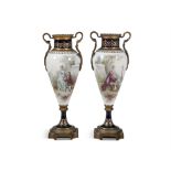 A PAIR OF SEVRES STYLE PORCELAIN URNS each depicting scenes of lovers in a classical garden