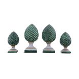 A SET OF FOUR PINEAPPLE FINIAL DECORATIVE ORNAMENTS painted green, each signed 'G.