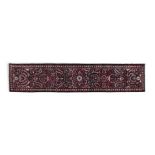 A SEMI-ANTIQUE PERSIAN RUNNER with red, cream and blue floral decoration, against a navy ground.