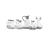 A COLLECTION OF FIVE CLEAR GLASS OIL JARS of conical form with silver hinged lids,