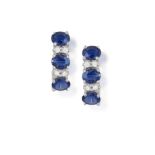 A PAIR OF SAPPHIRE AND DIAMOND EARRINGS, each frontispiece set with three oval-shaped sapphires