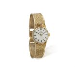 A LADY'S 9CT GOLD WRISTWATCH, BY OMEGA, of manual wind movement, the circular white dial,
