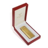 A GOLD PLATED LIGHTER BY CARTIER, of brushed texture with tri-coloured trinity ring detailing,