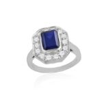 A BLUE AND COLOURLESS STONE RING, set with a rectangular-shaped blue stone, within an octagonal