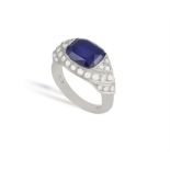 A SYNTHETIC SAPPHIRE AND DIAMOND RING, centering a cushion-shaped synthetic sapphire,