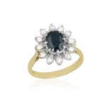 A SAPPHIRE AND DIAMOND RING, of bi-coloured cluster design, centering an oval sapphire,