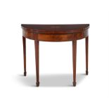 A GEORGIAN INLAID MAHOGANY DEMI-LUNE CARD TABLE, the top carved with a central shell motif,