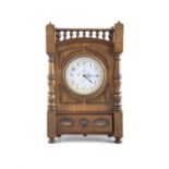 AN ARTS & CRAFTS WALNUT CASED MANTLE CLOCK, in the manner of Lewis F Day, the arch top with