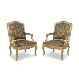 A PAIR OF LOUIS QUINZE STYLE CARVED AND GILDED ARMCHAIRS the crest with foliate scrollwork,