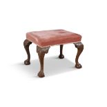AN UPHOLSTERED CARVED MAHOGANY STOOL, C.1900 of rectangular form, covered in a pink velour,