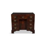 A GEORGE III RECTANGULAR KNEEHOLE DESK with plain crossbanded top above a brushing slide and