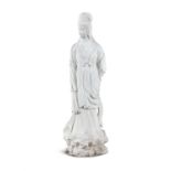 A CHINESE CARVED WHITE MARBLE STANDING FIGURE OF A GUANJIN standing on a rocky mound. 133cm high