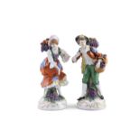 A PAIR OF CHELSEA POLYCHROME PORCELAIN FIGURES, of male and female fruit sellers. 22.6cm high