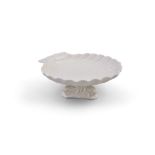 A FIRST PERIOD BELLEEK SERVING DISH, the shell dish covered in cream glaze, raised on fish