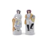 A PAIR OF STAFFORDSHIRE FIGURES OF FISHMONGERS, with baskets in their arms, 38cms high