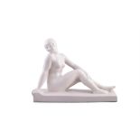 AN ART DECO PINK GLAZED POTTERY FIGURE OF A SEATED NUDE, raised on a rectangular base. 43 x 16.