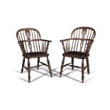A PAIR OF STAINED ELM WINDSOR ARMCHAIRS, 19TH CENTURY with arched stick-backs and solid seats, on