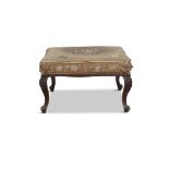 A VICTORIAN CARVED MAHOGANY FOOTSTOOL, with distressed tapestry covering The top 63 x 54cm