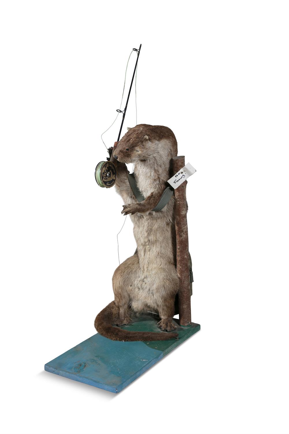 TAXIDERMY An anthropomorphic otter, displayed standing in an upright position as a fisherman with - Image 2 of 2